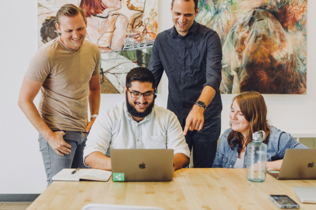 Darren and Mike MLM Success and How the Dream Team Model Differs from a Pyramid Scheme Team of online business mentors reviewing digital marketing strategy together on a laptop